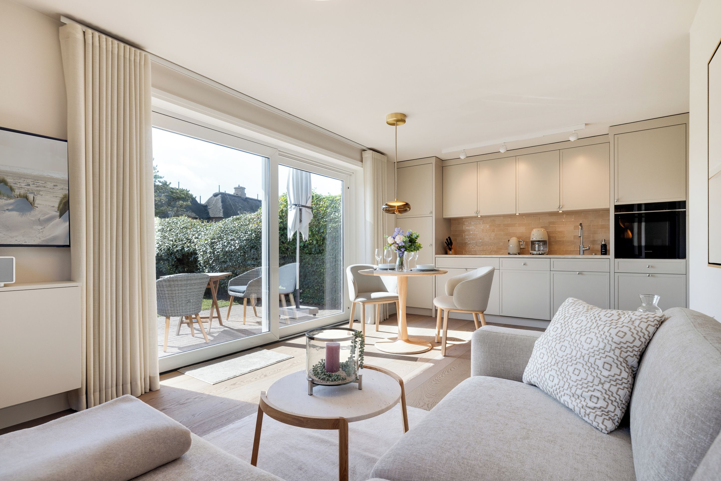 A modern living room with a sofa, a coffee table, and a dining area with chairs and a table.