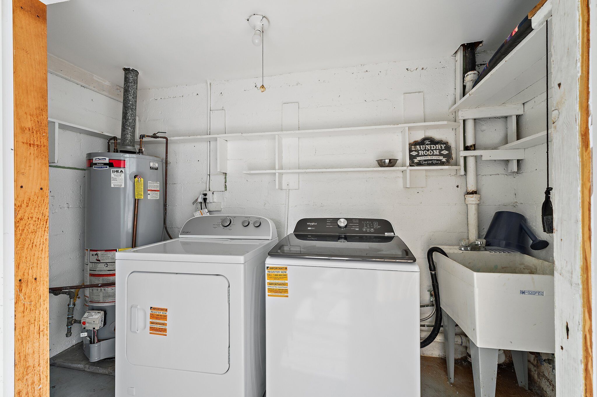 A laundry room with a washer, dryer, and a sign indicating it's the laundry room.
