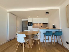 A modern kitchen with white cabinets, a built-in microwave, and a coffee machine. - Seafront Apartment in Middelkerke (Middelkerke)