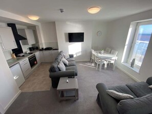 Un appartement moderne comprenant une cuisine, un coin repas et un salon.
