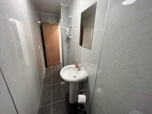 A bathroom with a white sink, a mirror, and a shower. - Harbour View Apt, Oceana (East Riding of Yorkshire)