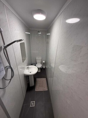 A modern bathroom with a shower, toilet, and sink. - Harbour View Apt, Oceana (East Riding of Yorkshire)
