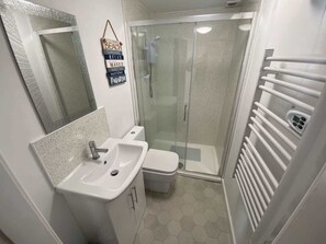 Ein Badezimmer mit Dusche, Toilette und Waschbecken.