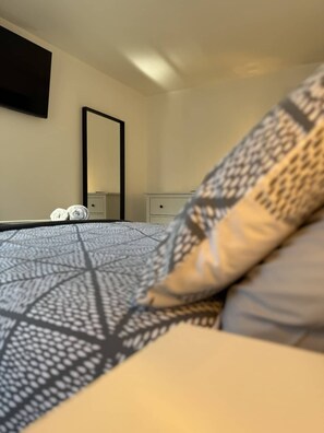 A bedroom with a bed, a nightstand, a dresser, and a mirror. - Seaside Escapes Apt. 5 (East Riding of Yorkshire)