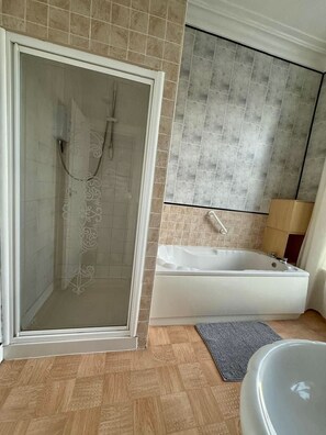 A bathroom with a walk-in shower, a bathtub, and a toilet. - Promenade Apt. Oceana (East Riding of Yorkshire)