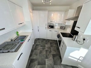 A modern kitchen with white cabinets, a microwave, a toaster, and a sink. - Large luxury property, sea view (East Riding of Yorkshire)