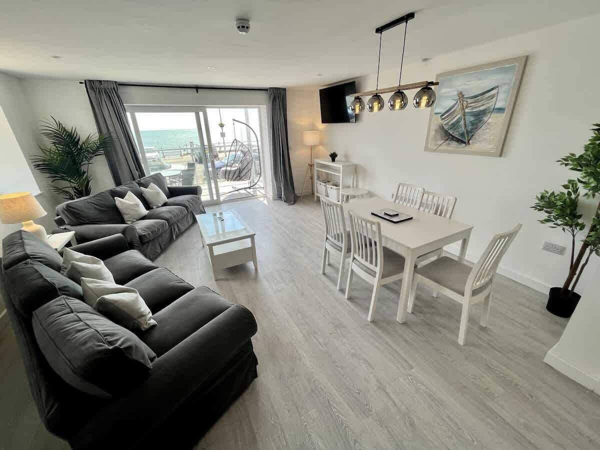 A modern living room with a sofa set, dining table, and chairs.