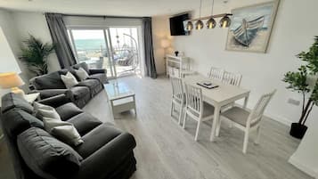 A modern living room with a sofa set, dining table, and chairs.