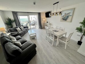 A modern living room with a sofa set, dining table, and chairs. - Seaside Escapes Apt. 2 (East Riding of Yorkshire)