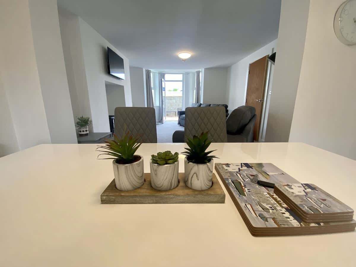 A dining table with three potted plants and a decorative piece.