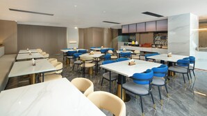 Un restaurante moderno con suelo de mármol, varias mesas y sillas.