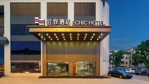 Un hotel con fachada moderna, un letrero llamativo y una entrada bien iluminada.