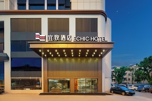 Un hotel con una facciata moderna, un cartello ben visibile e un ingresso illuminato.