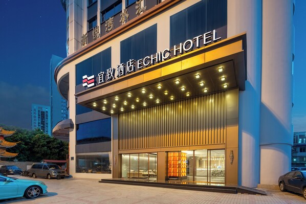 Un hotel con fachada moderna, amplios ventanales y un letrero llamativo.
