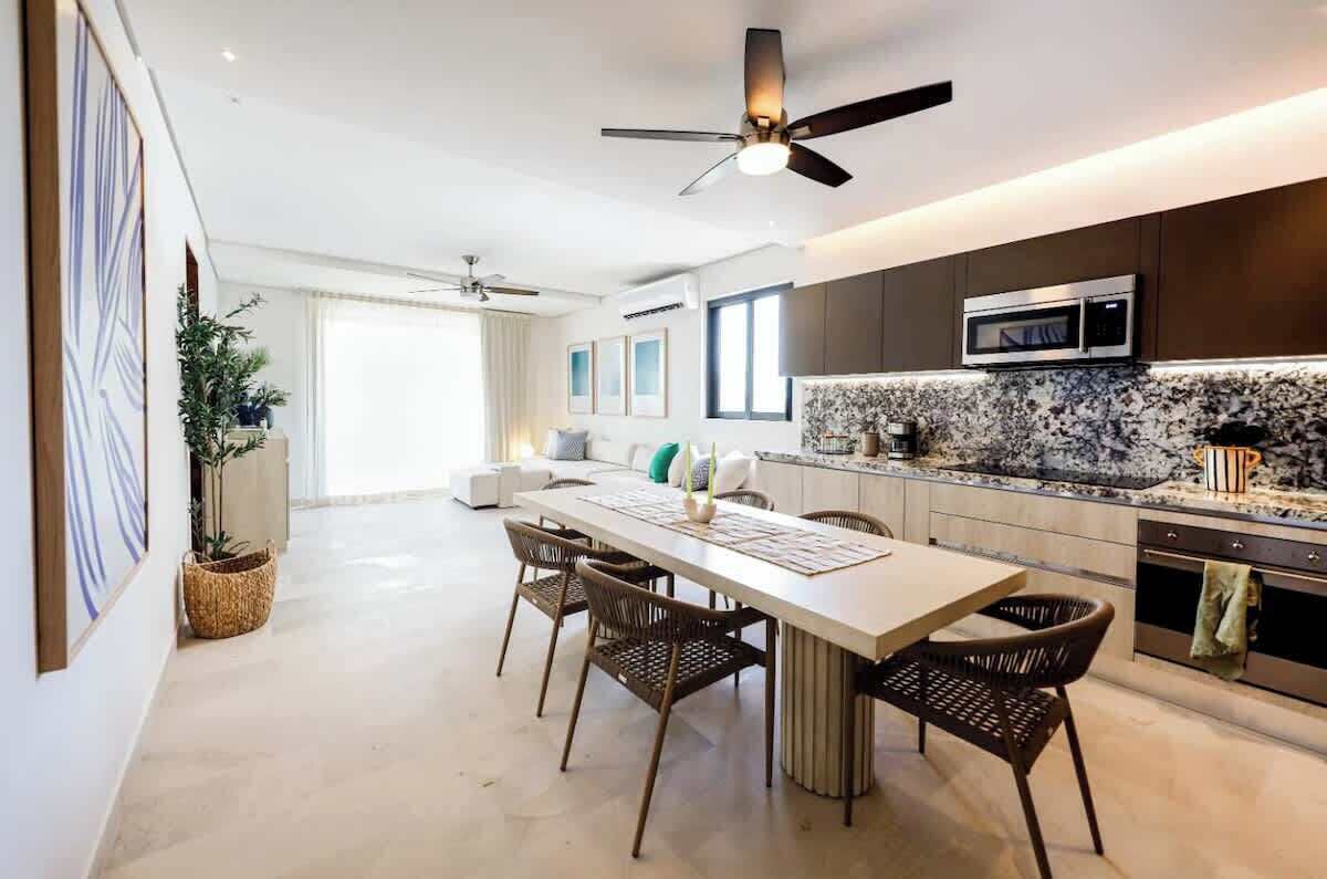 Eine moderne Küche mit Mikrowelle, ein Essbereich mit Tisch und Stühlen sowie ein Deckenventilator.