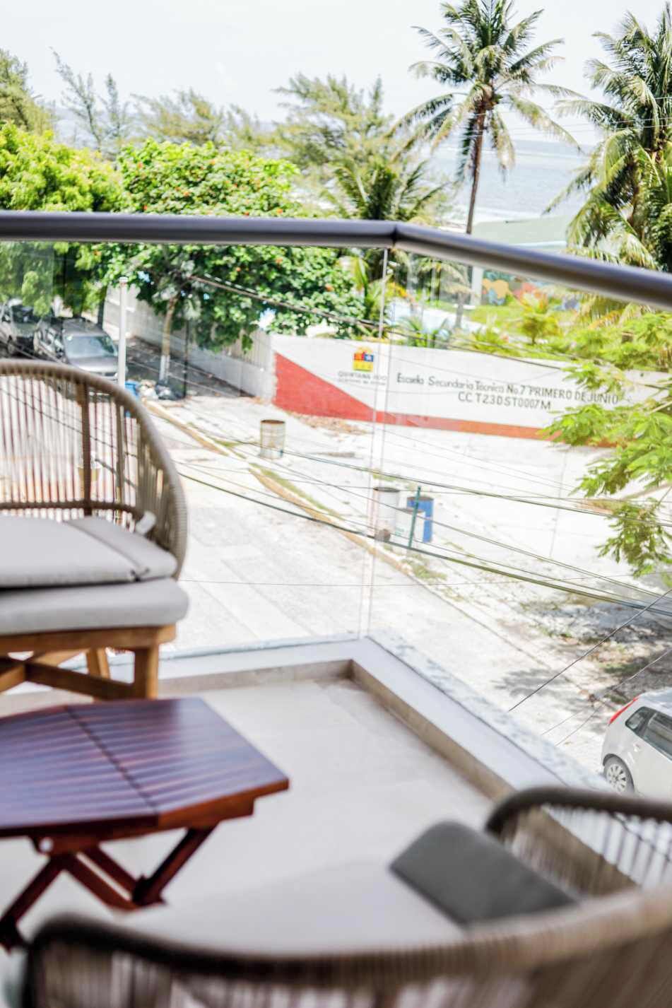 Ein Balkon mit Blick auf eine Straße, ein Stuhl und ein Tisch.