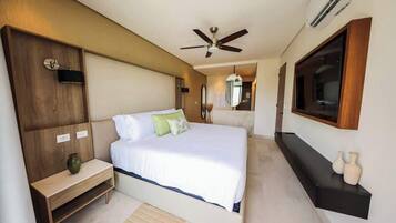 A bedroom with a bed, bedside table, and a TV mounted on the wall.