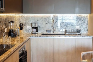 Eine Küche mit Granit Arbeitsplatte, einer Kaffeemaschine und einem Spülbecken.