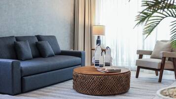 Een moderne woonkamer met een bank, een rond bijzettafeltje en een lamp.