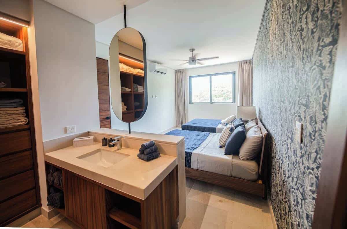 Ein modernes Schlafzimmer mit einem großen Bett, einem Nachttisch, einem eingebauten Kleiderschrank und einem großen Fenster.