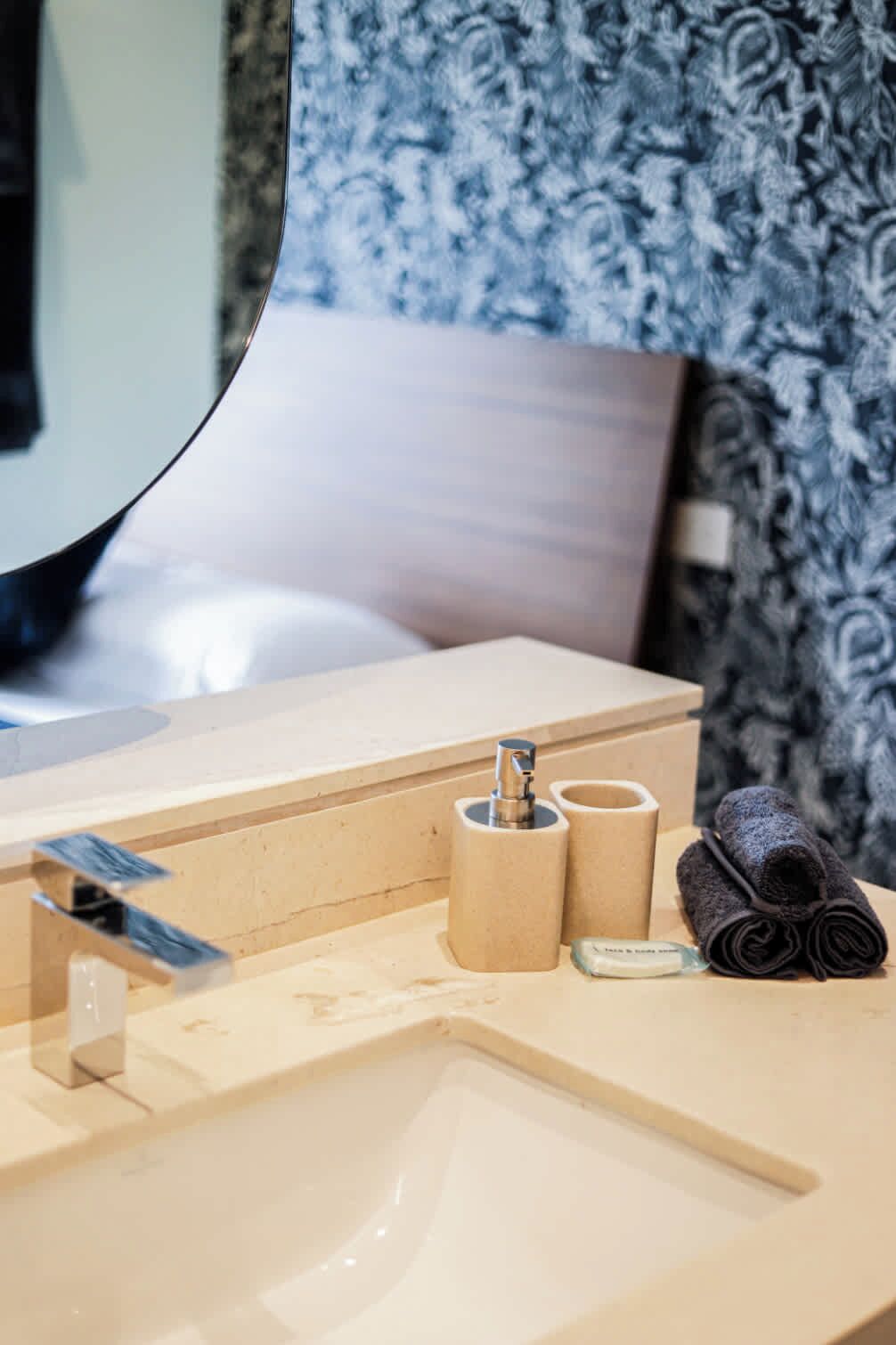 Une salle de bain avec un lavabo, un miroir et une serviette.