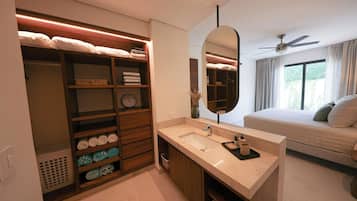 A modern bathroom with a built-in vanity, a large mirror, and a ceiling fan.