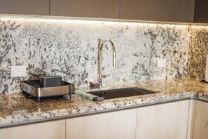 A kitchen with a granite countertop, stainless steel appliances, and a modern faucet. - PH Tucán: Private Terrace and Ocean View rooftop (Puerto Morelos)