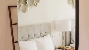 A bedroom with a bed, a bedside table, a lamp, and wall decor. - PH Tucán: Private Terrace and Ocean View rooftop (Puerto Morelos)