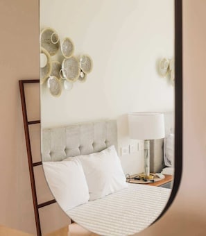 A bedroom with a bed, a bedside table, a lamp, and wall decor. - PH Tucán: Private Terrace and Ocean View rooftop (Puerto Morelos)