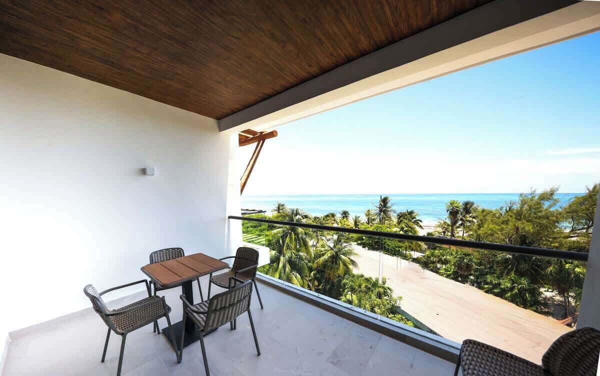 Un balcon avec vue sur la plage et l’océan.