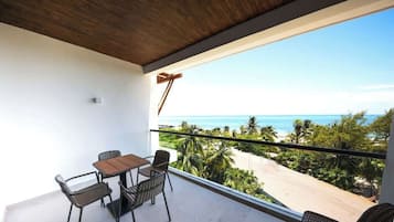 A balcony with a view of the beach and ocean.