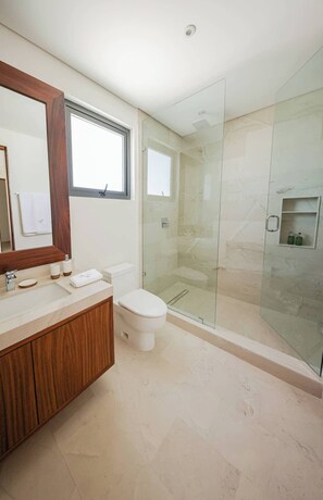 A modern bathroom with a glass-enclosed shower, a wooden vanity, and a large mirror. - Apt Mantarraya: Private Plunge Pool & Terrace (Puerto Morelos)