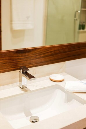 A bathroom with a white sink, a wooden-framed mirror, and a towel rack. - Apt Mantarraya: Private Plunge Pool & Terrace (Puerto Morelos)