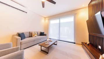 A modern living room with a sofa, a coffee table, and a ceiling fan.