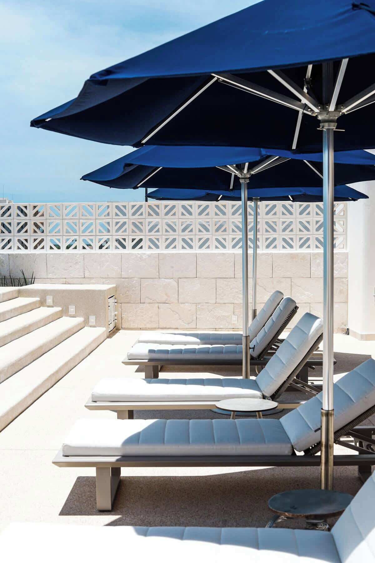 Un espace aménagé au bord de la piscine, avec des chaises longues et des parasols.