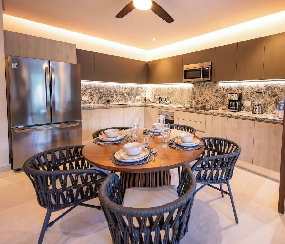 Eine moderne Küche mit Einbaukühlschrank, Mikrowelle und einer Arbeitsplatte aus Granit.