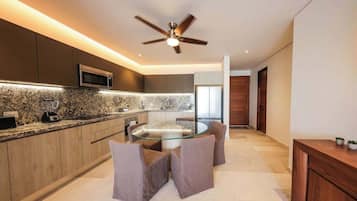 Una cocina moderna con una mesa de vidrio, armarios de madera y un ventilador de techo.