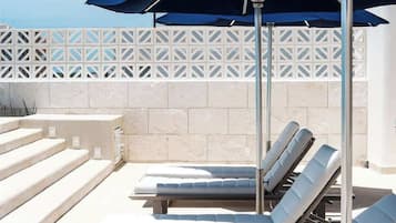 Un espace aménagé au bord de la piscine, avec des chaises longues et des parasols.