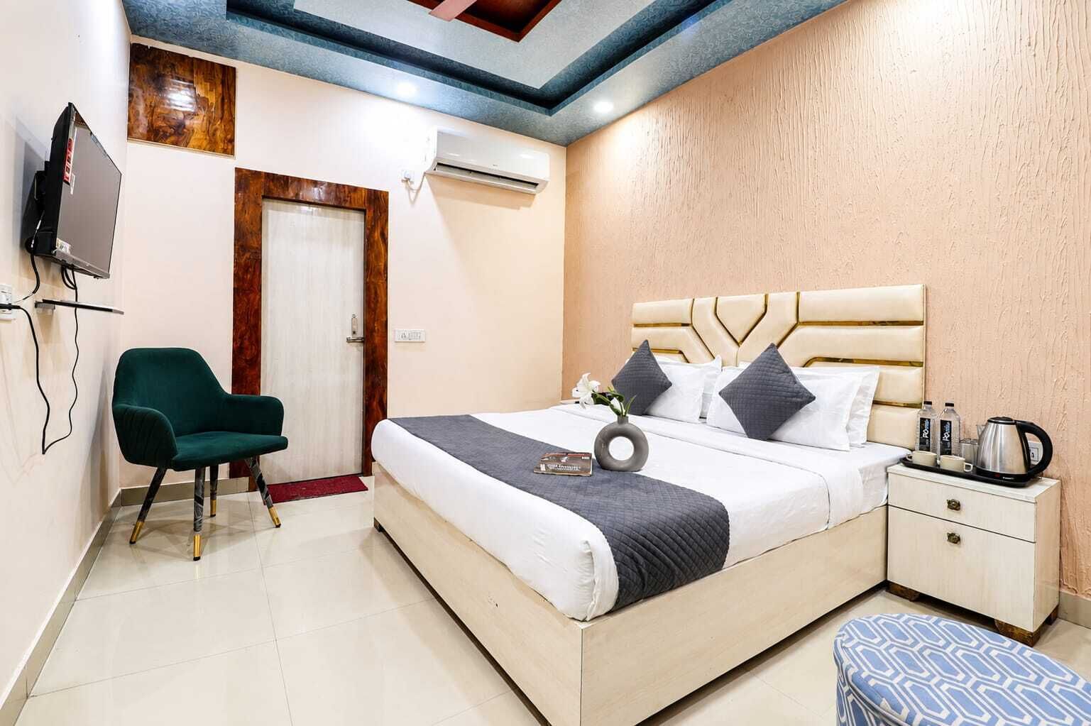 Een hotelkamer met een bed, nachtkastje, stoel en televisie.