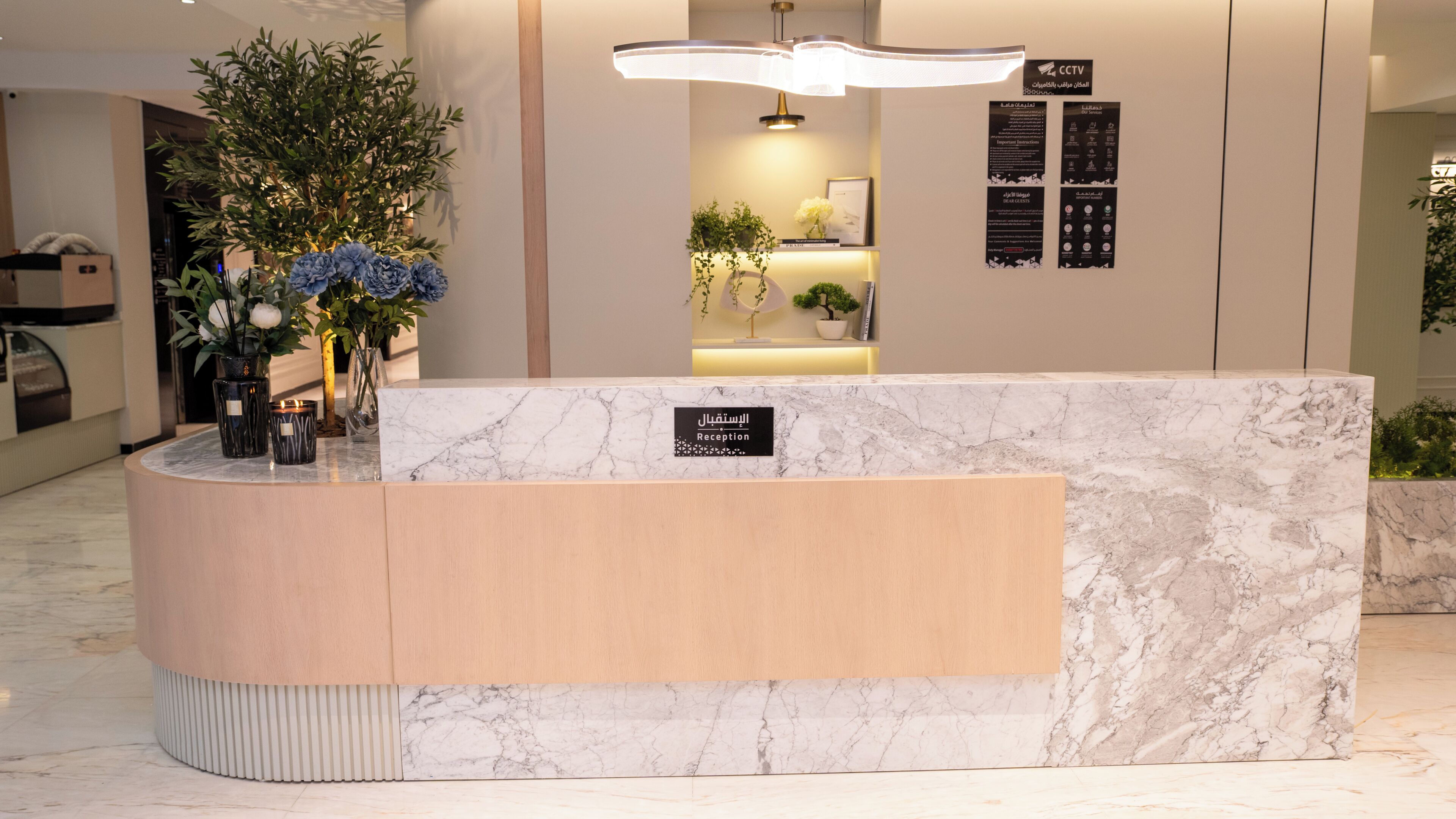 A reception desk with a marble top, a wooden panel, and a sign indicating it's the reception area.