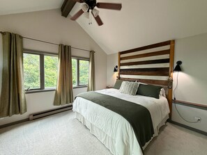 A bedroom with a bed, a ceiling fan, a window with curtains, a wall-mounted lamp, and a radiator. - breathtaking long-range views and contemporary décor,  3-bed, 2-bath condo (Sugar Mountain)