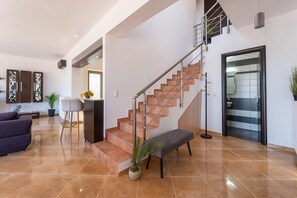Ein modernes Interieur mit Treppe, Sitzecke und Küche.