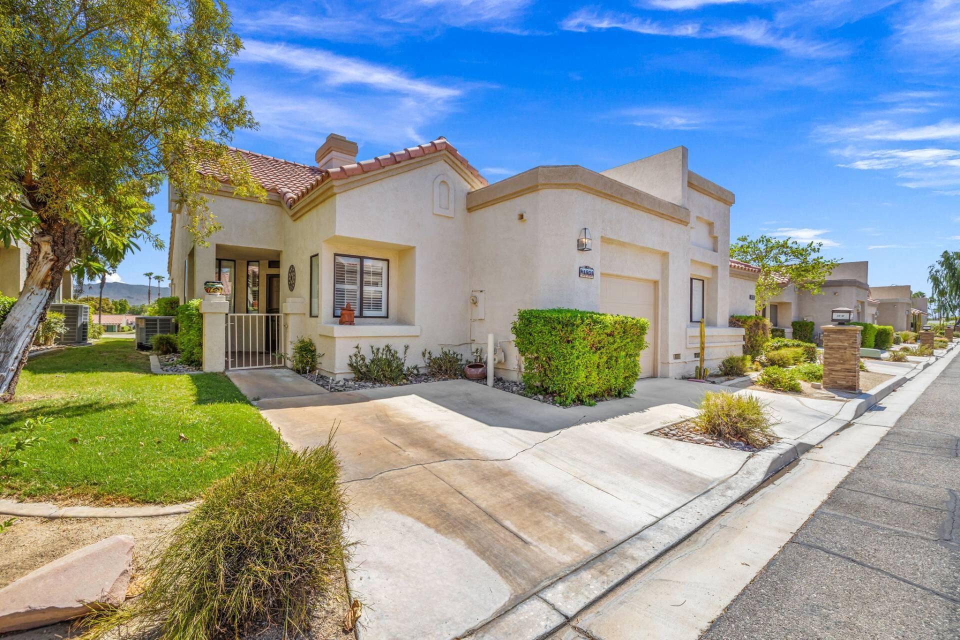 A residential house with a front yard, a driveway, and a street view.