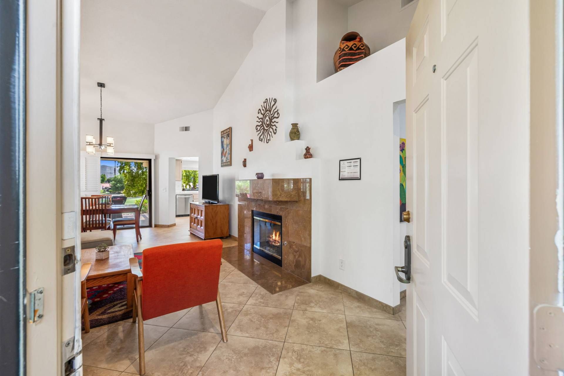 Un amplio espacio habitable con chimenea, una mesa de comedor con sillas y una cocina al fondo.