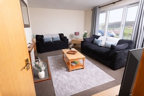A living room with two sofas, a coffee table, and a TV.