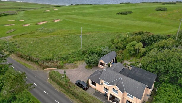 Ein Küstenanwesen mit Golfplatz, einer Straße und einem Gebäude mit Auffahrt.