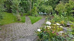 A garden pathway leading to a seating area with chairs. - Thorn Cottage by Escape Ordinary (Ballycastle)