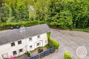 A two-story building with a gravel driveway and a fenced area. - Horseshoe Cottage by Escape Ordinary (Derrygonnelly)
