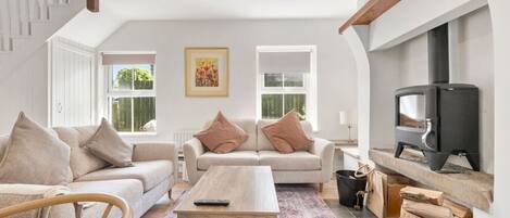 A cozy living room with a sofa, a coffee table, and a fireplace.