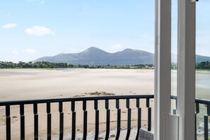 A view from a balcony overlooking a beach with mountains in the background. - The Lookout · Dundrum Bay · Balcony with Bay Views (Dundrum)